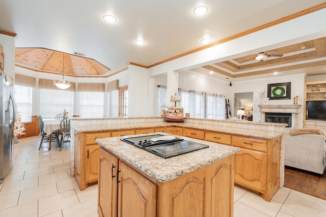 kitchen with pendant lighting, black electric stovetop, ornamental molding, and a kitchen island