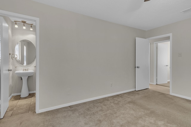 unfurnished bedroom featuring light carpet and connected bathroom