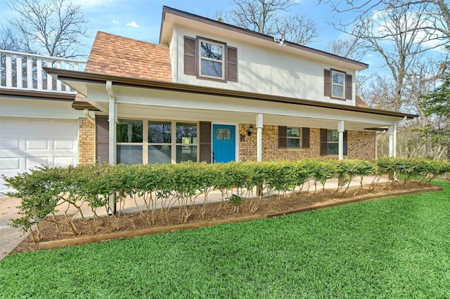 view of front of property with a garage, a front lawn, and a porch