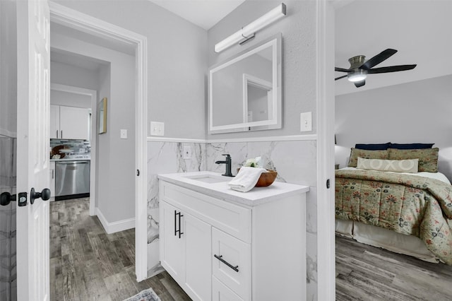 bathroom with ceiling fan, vanity, tile walls, and hardwood / wood-style floors