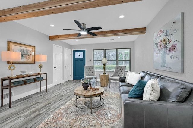 living room with ceiling fan, beam ceiling, and hardwood / wood-style floors