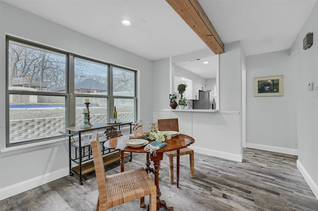 dining space featuring dark hardwood / wood-style flooring and beamed ceiling