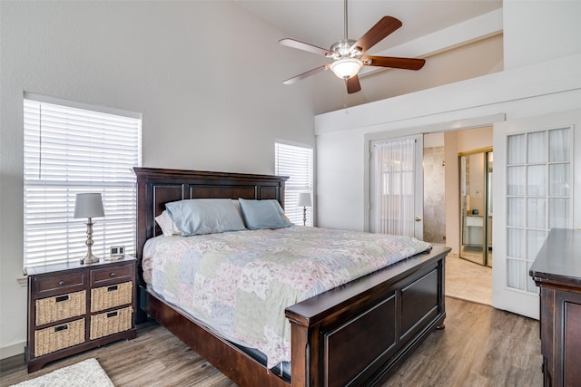 bedroom with ceiling fan, hardwood / wood-style flooring, and high vaulted ceiling