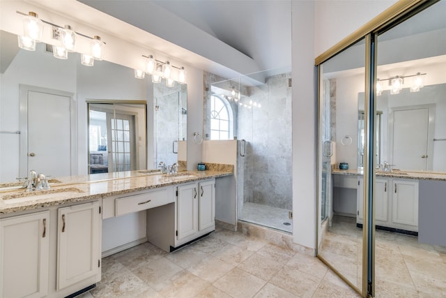 bathroom featuring a shower with door, lofted ceiling, and vanity