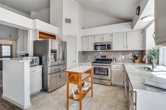 kitchen featuring light stone countertops, appliances with stainless steel finishes, sink, backsplash, and high vaulted ceiling