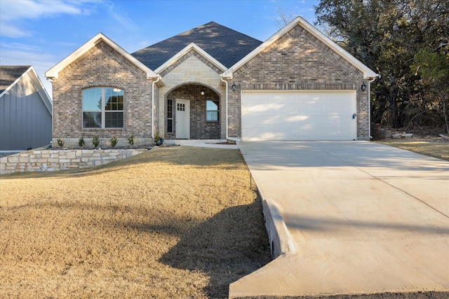 view of front of property with a garage and a front lawn