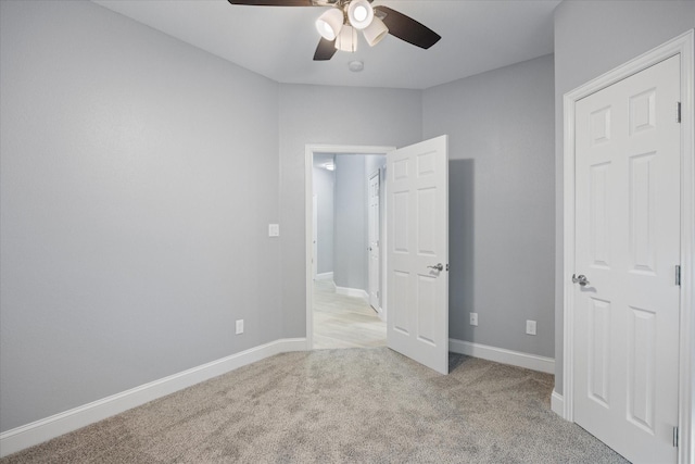 unfurnished bedroom featuring light colored carpet and ceiling fan