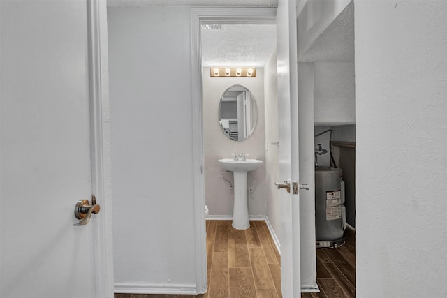 bathroom with hardwood / wood-style floors and water heater