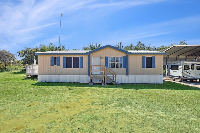 manufactured / mobile home with a front lawn and a carport