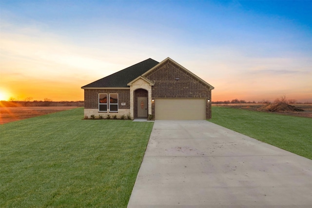 view of front of property with a garage and a lawn