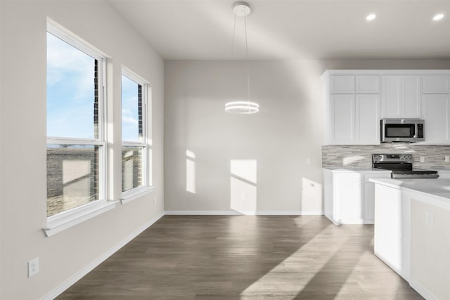 kitchen featuring tasteful backsplash, hardwood / wood-style floors, hanging light fixtures, stainless steel appliances, and white cabinets