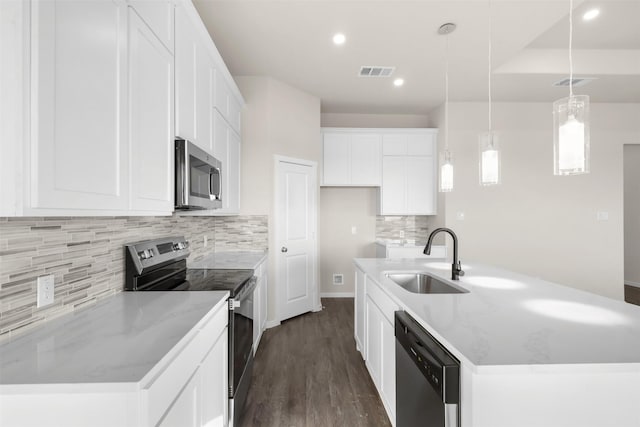 kitchen with appliances with stainless steel finishes, decorative light fixtures, white cabinetry, sink, and light stone counters