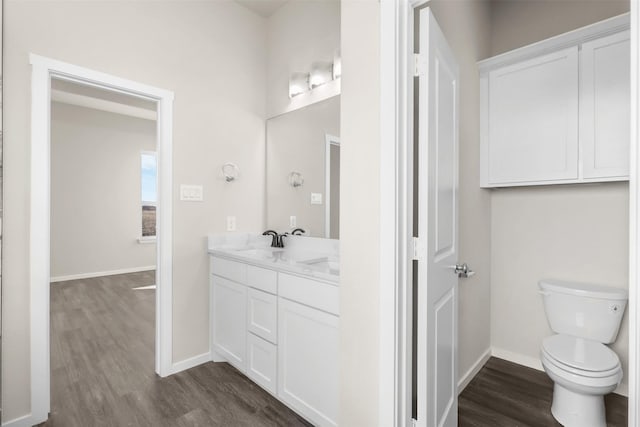 bathroom with hardwood / wood-style flooring, toilet, and vanity