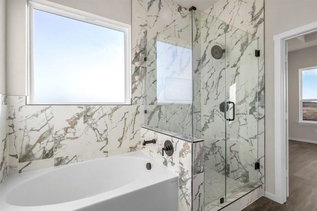 bathroom featuring independent shower and bath, wood-type flooring, and plenty of natural light