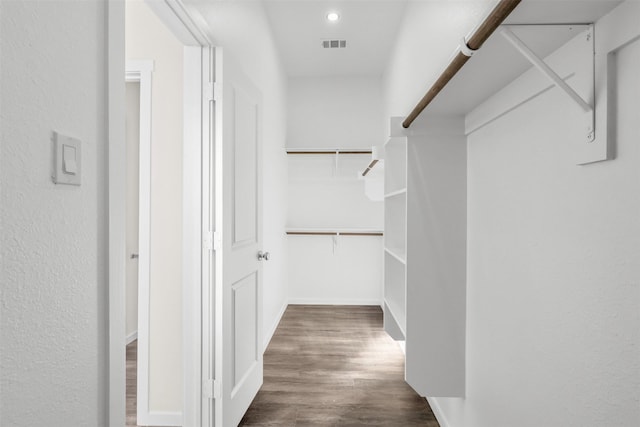 walk in closet with dark wood-type flooring