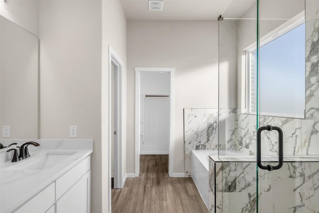 bathroom with hardwood / wood-style flooring, vanity, and shower with separate bathtub