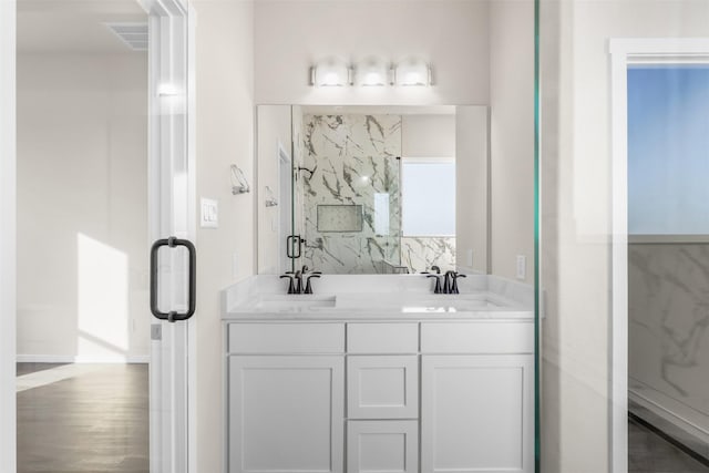 bathroom featuring hardwood / wood-style floors, a shower with door, and vanity