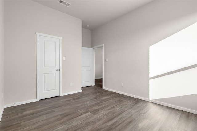 unfurnished room with dark wood-type flooring