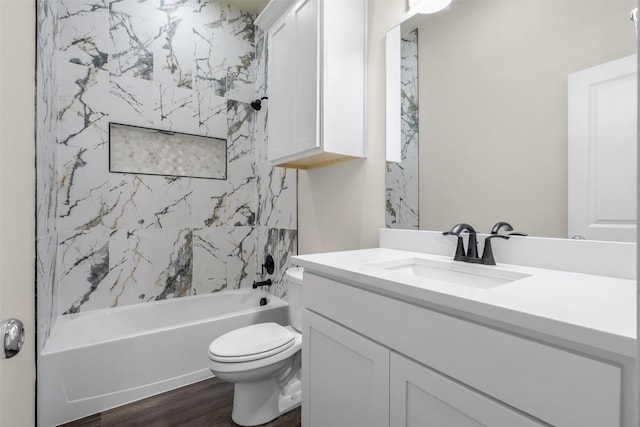 full bathroom with hardwood / wood-style floors, toilet, vanity, and tiled shower / bath combo