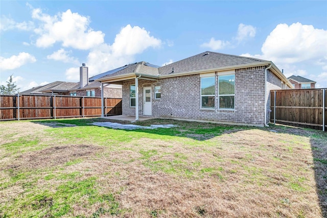 rear view of property featuring a lawn and a patio