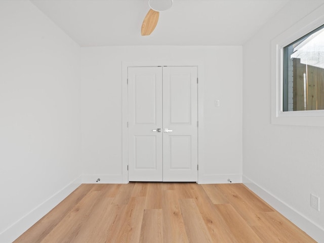 unfurnished bedroom featuring light hardwood / wood-style floors, a closet, and ceiling fan