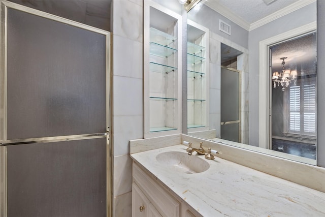 bathroom with a textured ceiling, a shower with door, vanity, an inviting chandelier, and crown molding