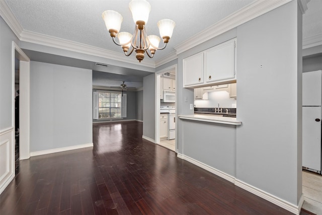 kitchen with white cabinetry, decorative light fixtures, white appliances, ornamental molding, and ceiling fan with notable chandelier