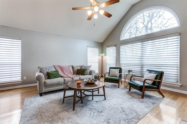 living room featuring light hardwood / wood-style floors, ceiling fan, and vaulted ceiling