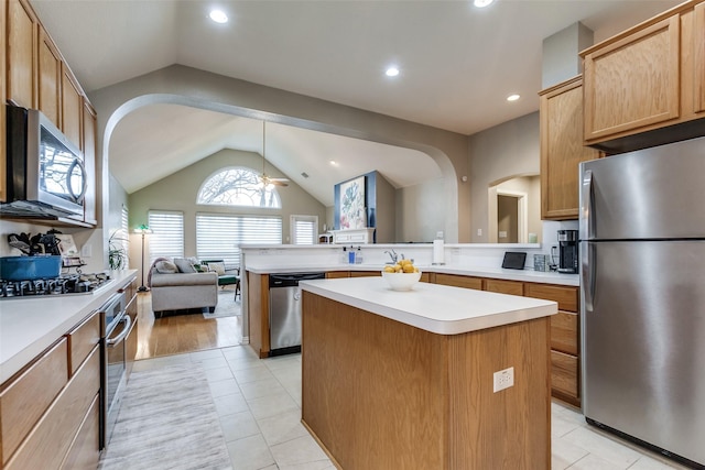 kitchen featuring vaulted ceiling, pendant lighting, a kitchen island, stainless steel appliances, and light tile patterned floors