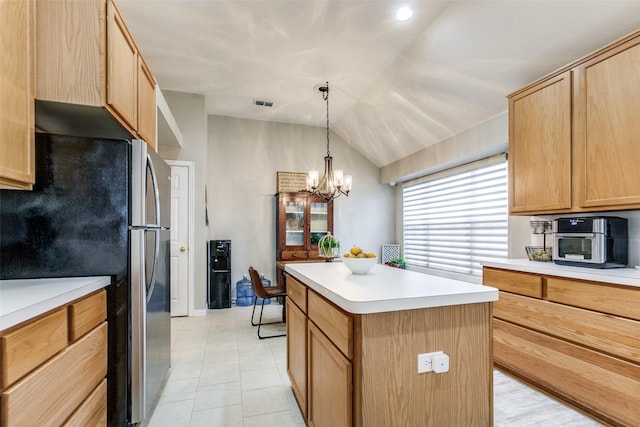 kitchen featuring lofted ceiling, decorative light fixtures, a center island, stainless steel refrigerator, and a chandelier