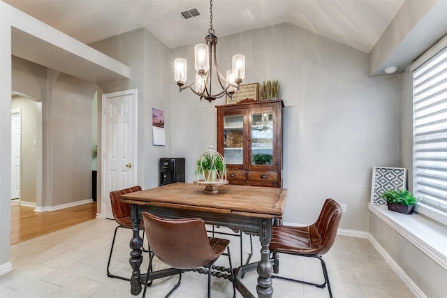 tiled dining room with lofted ceiling and a notable chandelier