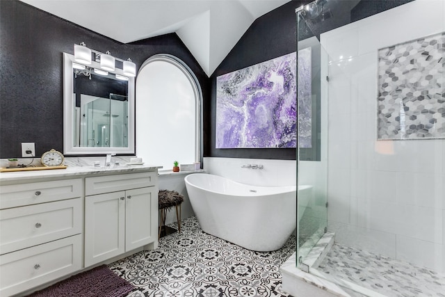 bathroom with tile walls, vanity, lofted ceiling, and plus walk in shower