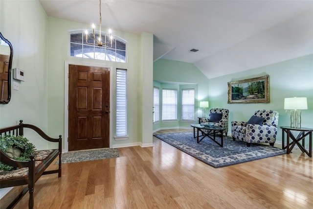 foyer featuring a chandelier, lofted ceiling, and hardwood / wood-style flooring