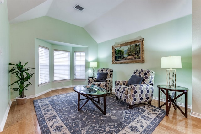 living area with light wood-type flooring and vaulted ceiling