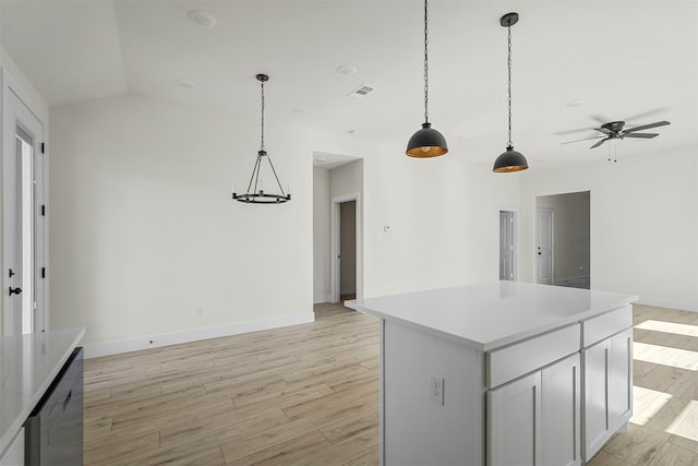 kitchen with decorative light fixtures, ceiling fan, vaulted ceiling, a kitchen island, and light hardwood / wood-style flooring