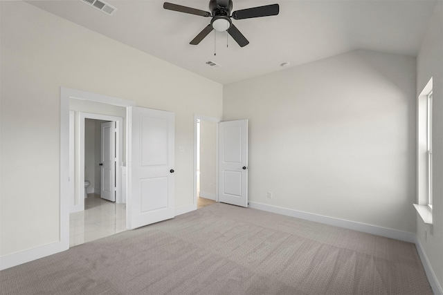 unfurnished bedroom with ceiling fan, lofted ceiling, and light carpet