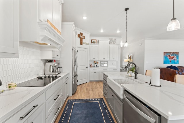 kitchen with white cabinets, hanging light fixtures, and appliances with stainless steel finishes