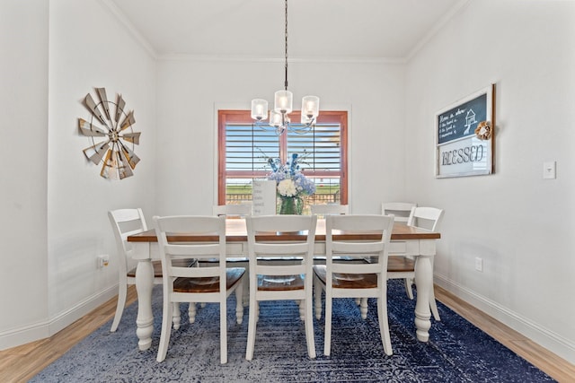 dining area with crown molding, a chandelier, and hardwood / wood-style floors