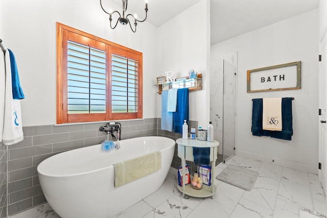 bathroom featuring tile walls, an inviting chandelier, and shower with separate bathtub