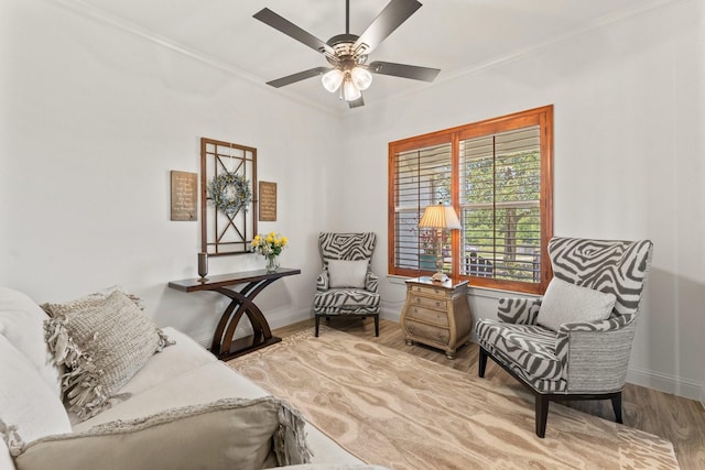 living area with ceiling fan, ornamental molding, and hardwood / wood-style flooring