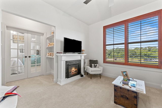 living room featuring light carpet, ceiling fan, built in features, and french doors