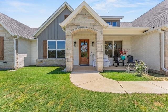 view of exterior entry featuring a lawn