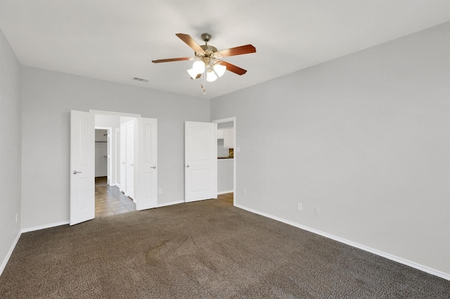 unfurnished bedroom with visible vents, baseboards, a ceiling fan, and carpet flooring