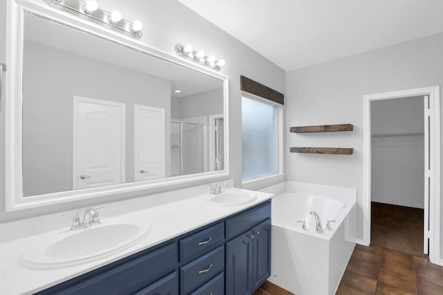 bathroom with a sink, a garden tub, a shower stall, and double vanity