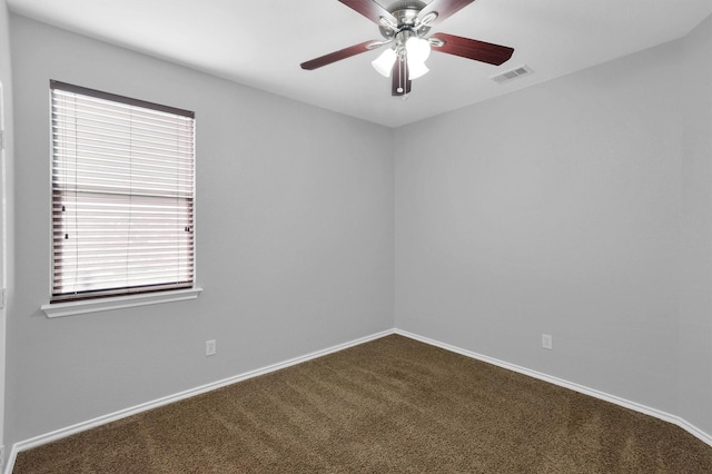 empty room with a ceiling fan, baseboards, visible vents, and dark carpet