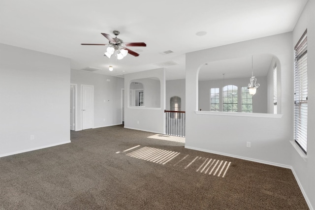 spare room with visible vents, baseboards, a ceiling fan, and dark carpet