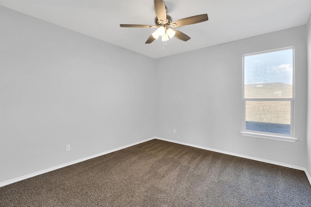 unfurnished room with a wealth of natural light, baseboards, and dark colored carpet