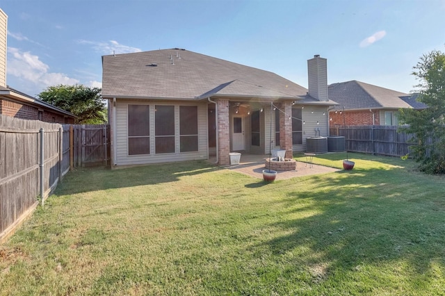 back of house featuring a patio, a fire pit, a lawn, and a fenced backyard