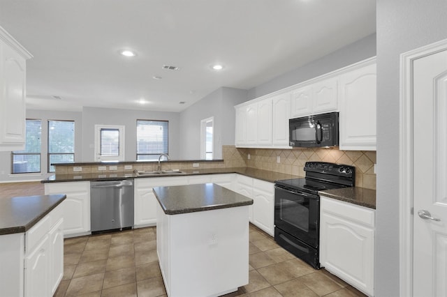 kitchen featuring visible vents, black appliances, a sink, dark countertops, and a peninsula