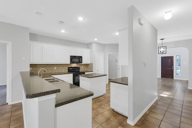 kitchen featuring light tile patterned floors, decorative backsplash, white cabinets, black appliances, and a sink